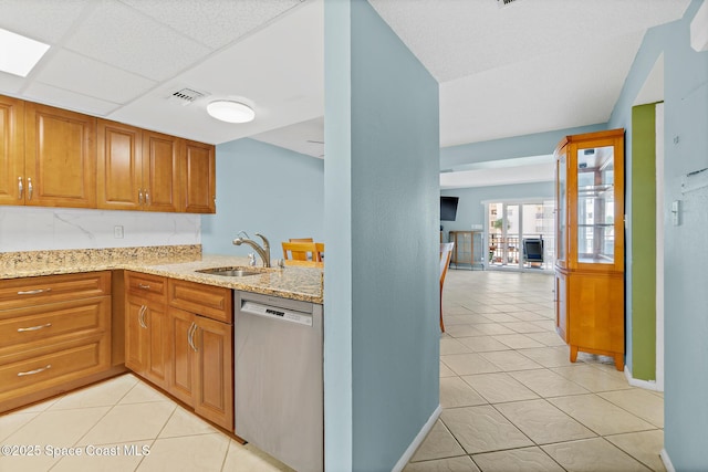 1700 N Atlantic Ave Unit 133, Cocoa Beach, FL 32931 - kitchen with stainless steel dishwasher, light stone countertops, and light tile patterned floors