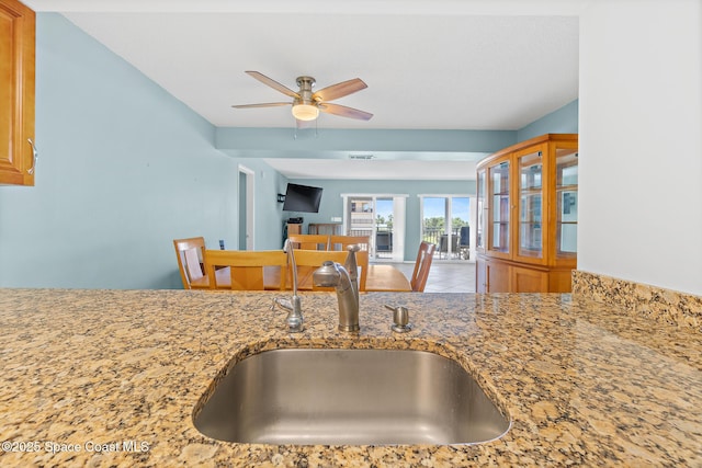 1700 N Atlantic Ave Unit 133, Cocoa Beach, FL 32931 - kitchen featuring ceiling fan, light stone countertops, and tile patterned floors