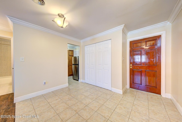350 Taylor Ave Unit 2B3, Cape Canaveral, FL 32920 - unfurnished bedroom with freestanding refrigerator, crown molding, a closet, light tile patterned floors, and baseboards