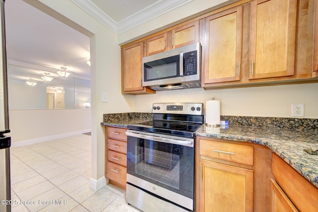350 Taylor Ave Unit 2B3, Cape Canaveral, FL 32920 - kitchen featuring stainless steel appliances, crown molding, light tile patterned floors, baseboards, and dark stone countertops