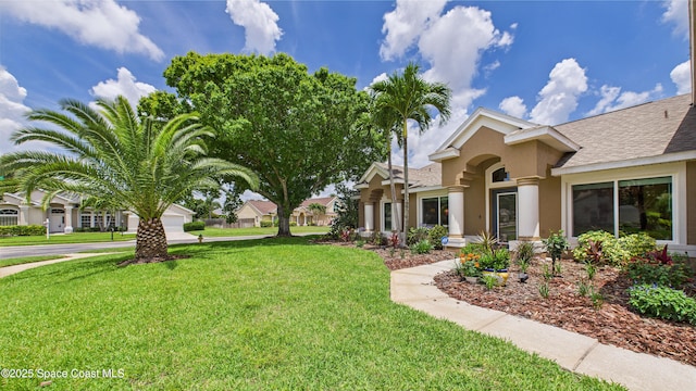 3266 Helmsdale Ct, Melbourne, FL 32940 - view of front of home with stucco siding, a front yard, and roof with shingles