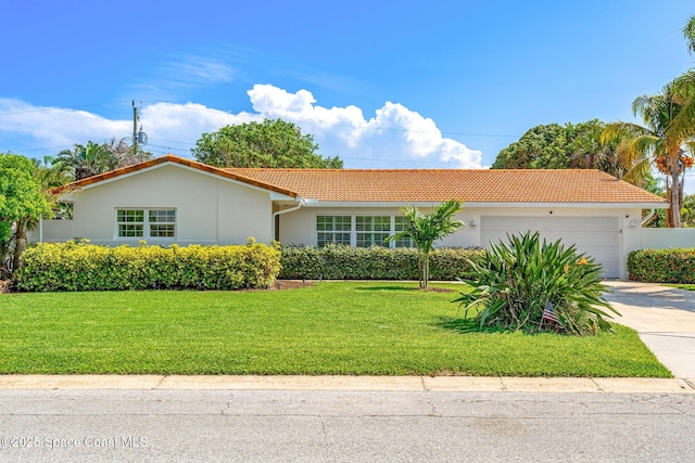 345 Dorset Dr, Cocoa Beach, FL 32931 - view of front of property with a tile roof, an attached garage, driveway, stucco siding, and a front lawn