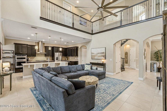 2228 Zuma Ln, Melbourne, FL 32940 - living area featuring arched walkways, ornamental molding, a high ceiling, recessed lighting, and light tile patterned floors
