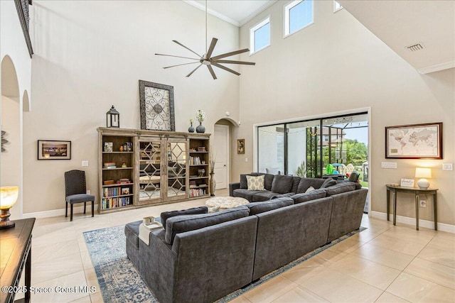 2228 Zuma Ln, Melbourne, FL 32940 - living room featuring arched walkways, a high ceiling, a ceiling fan, light tile patterned flooring, and ornamental molding