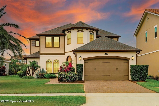 2228 Zuma Ln, Melbourne, FL 32940 - view of front facade featuring decorative driveway, a garage, stucco siding, and roof with shingles