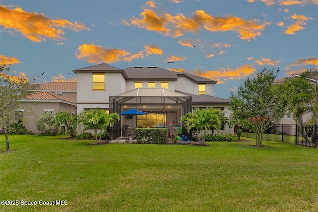 2228 Zuma Ln, Melbourne, FL 32940 - back of house at dusk featuring a patio, glass enclosure, and stucco siding