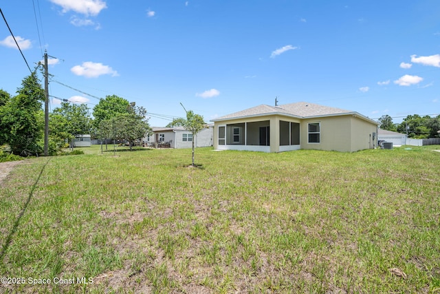 1650 Wyoming Dr SE, Palm Bay, FL 32909 - view of green lawn featuring a sunroom and central AC