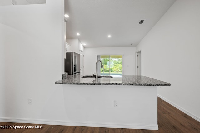 1650 Wyoming Dr SE, Palm Bay, FL 32909 - kitchen with a sink, stainless steel refrigerator with ice dispenser, dark stone countertops, white cabinetry, and dark wood-style flooring
