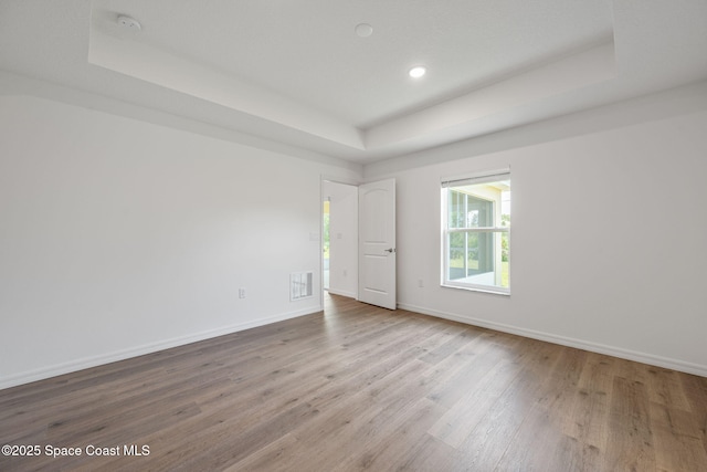 1650 Wyoming Dr SE, Palm Bay, FL 32909 - empty room with a tray ceiling, wood finished floors, baseboards, and recessed lighting