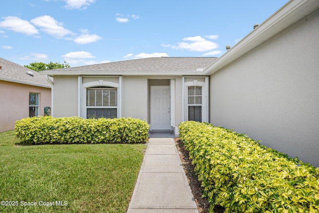 2268 Spring Creek Cir, Palm Bay, FL 32905 - property entrance with stucco siding, a lawn, and a shingled roof