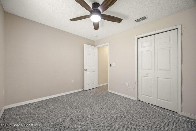 2268 Spring Creek Cir, Palm Bay, FL 32905 - unfurnished bedroom with carpet flooring, a textured ceiling, baseboards, a closet, and a ceiling fan