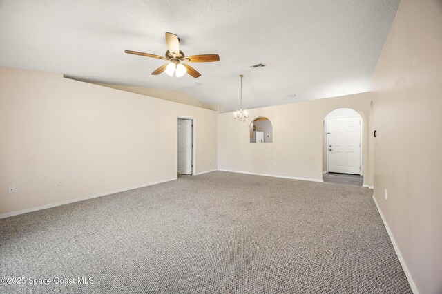 2268 Spring Creek Cir, Palm Bay, FL 32905 - carpeted spare room featuring a ceiling fan, vaulted ceiling, arched walkways, baseboards, and a chandelier