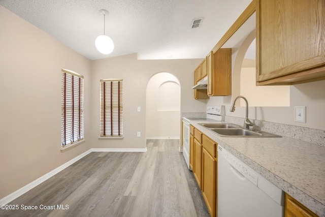 2268 Spring Creek Cir, Palm Bay, FL 32905 - kitchen featuring white appliances, arched walkways, under cabinet range hood, light wood-type flooring, and a sink