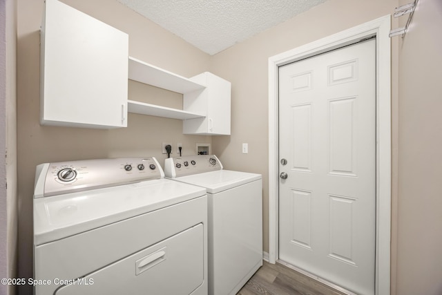 2268 Spring Creek Cir, Palm Bay, FL 32905 - laundry room with washer and dryer, wood finished floors, cabinet space, and a textured ceiling