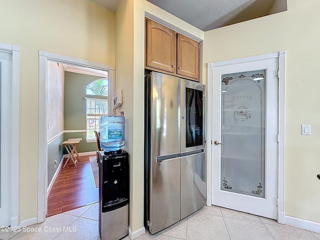 2050 SE Ellington Ter, Port St Lucie, FL 34952 - kitchen featuring smart refrigerator, light tile patterned flooring, and baseboards