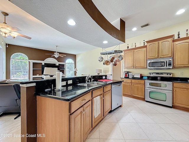 2050 SE Ellington Ter, Port St Lucie, FL 34952 - kitchen featuring stainless steel appliances, a sink, ceiling fan, a textured ceiling, and a kitchen island with sink