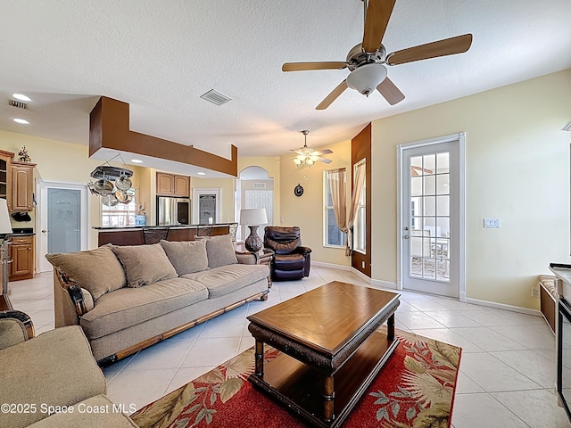 2050 SE Ellington Ter, Port St Lucie, FL 34952 - living area with light tile patterned flooring, a ceiling fan, healthy amount of natural light, a textured ceiling, and arched walkways