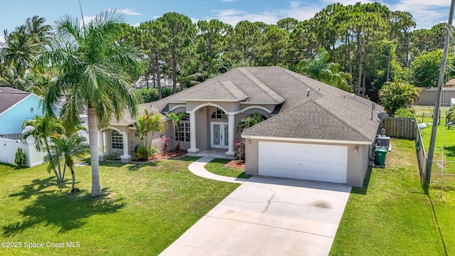 2050 SE Ellington Ter, Port St Lucie, FL 34952 - view of front of home featuring french doors, stucco siding, a garage, concrete driveway, and a shingled roof