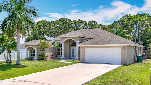 2050 SE Ellington Ter, Port St Lucie, FL 34952 - view of front facade with stucco siding, an attached garage, driveway, cooling unit, and a shingled roof