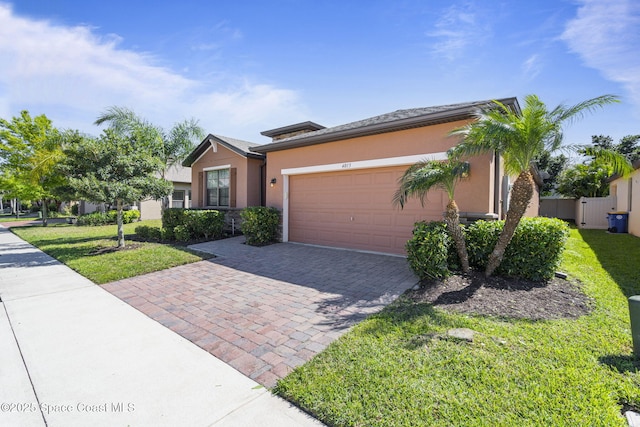 4015 Harvest Cir, Rockledge, FL 32955 - view of front of property with decorative driveway, an attached garage, stucco siding, and a front lawn