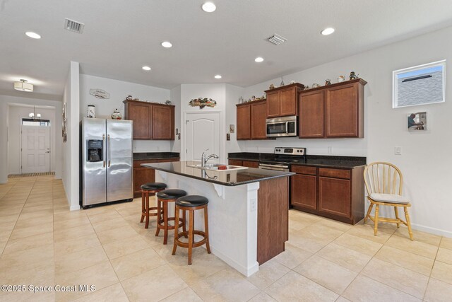 4015 Harvest Cir, Rockledge, FL 32955 - kitchen with stainless steel appliances, a sink, a breakfast bar, recessed lighting, and a kitchen island with sink