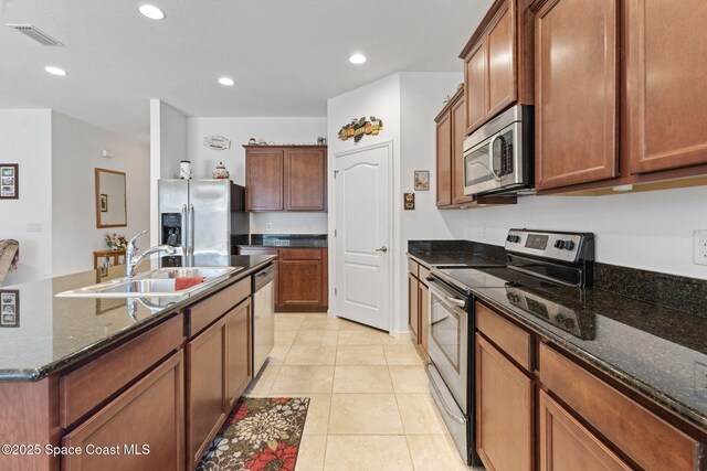 4015 Harvest Cir, Rockledge, FL 32955 - kitchen featuring stainless steel appliances, a sink, dark stone counters, recessed lighting, and light tile patterned floors