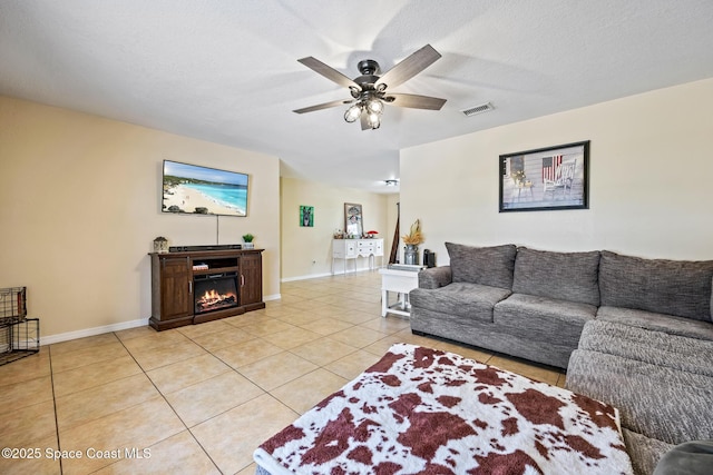 946 Stage St SE, Palm Bay, FL 32909 - living room featuring light tile patterned floors, a ceiling fan, a glass covered fireplace, and baseboards