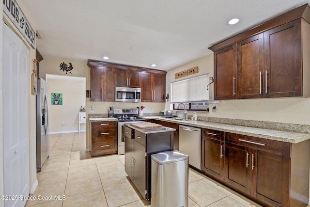 946 Stage St SE, Palm Bay, FL 32909 - kitchen featuring stainless steel appliances, a sink, light tile patterned flooring, a kitchen island, and recessed lighting