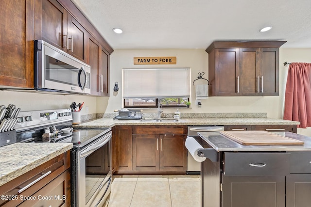 946 Stage St SE, Palm Bay, FL 32909 - kitchen with stainless steel appliances, a sink, light tile patterned floors, recessed lighting, and light stone counters