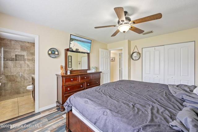 946 Stage St SE, Palm Bay, FL 32909 - bedroom with a closet, a ceiling fan, connected bathroom, baseboards, and wood finished floors
