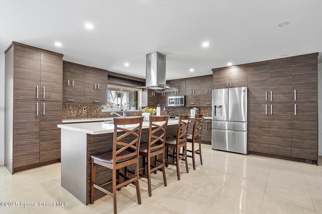 253 NE 212th Ter, Miami, FL 33177 - kitchen with stainless steel appliances, island exhaust hood, decorative backsplash, a kitchen bar, and recessed lighting