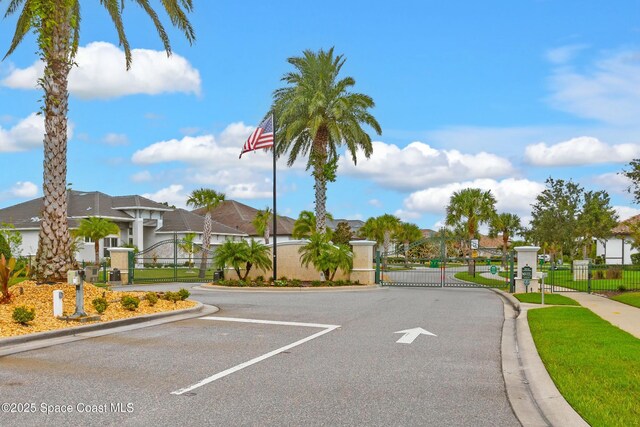 3933 Craigston St, Melbourne, FL 32940 - view of asphalt road featuring a gate, curbs, a gated entry, and a residential view