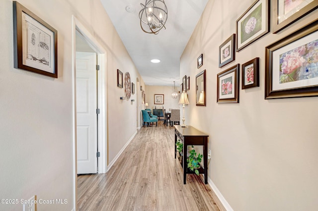 2263 Chinaberry Cir SE, Palm Bay, FL 32909 - corridor with a chandelier, light wood-type flooring, recessed lighting, and baseboards