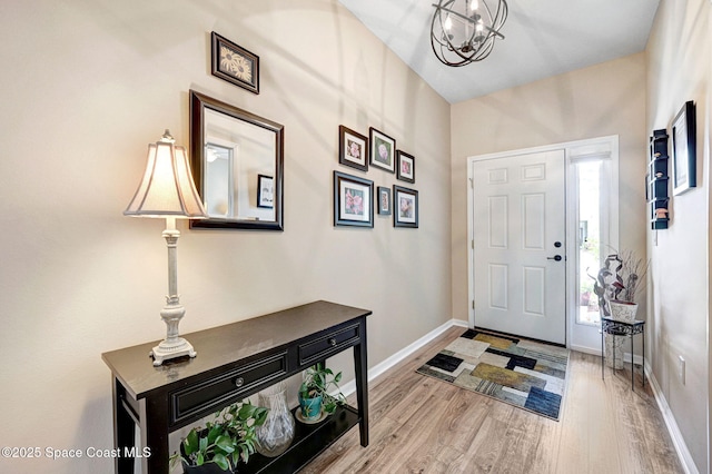 2263 Chinaberry Cir SE, Palm Bay, FL 32909 - foyer with light wood finished floors, baseboards, and a chandelier