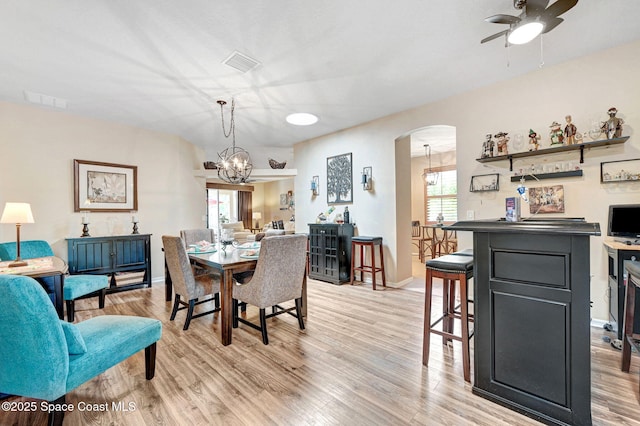 2263 Chinaberry Cir SE, Palm Bay, FL 32909 - dining space featuring ceiling fan, arched walkways, light wood-style floors, and a chandelier