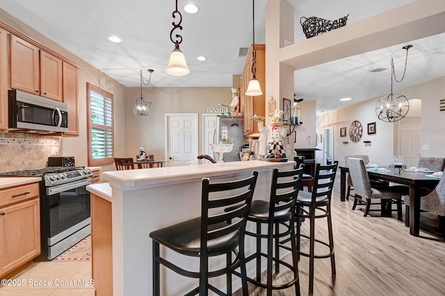 2263 Chinaberry Cir SE, Palm Bay, FL 32909 - kitchen with stainless steel appliances, light countertops, recessed lighting, light brown cabinetry, and backsplash
