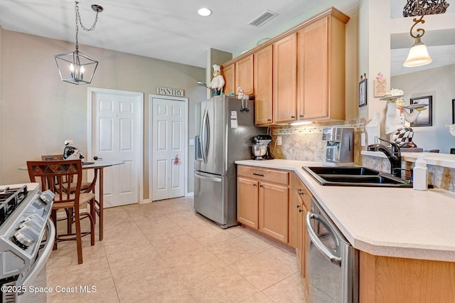 2263 Chinaberry Cir SE, Palm Bay, FL 32909 - kitchen with appliances with stainless steel finishes, a sink, light countertops, backsplash, and pendant lighting