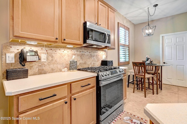 2263 Chinaberry Cir SE, Palm Bay, FL 32909 - kitchen with stainless steel appliances, decorative backsplash, light brown cabinets, a chandelier, and light countertops