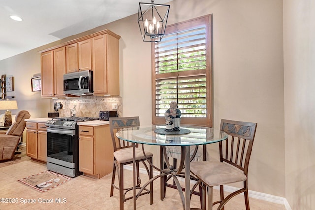 2263 Chinaberry Cir SE, Palm Bay, FL 32909 - kitchen featuring appliances with stainless steel finishes, light brown cabinets, tasteful backsplash, a chandelier, and light countertops