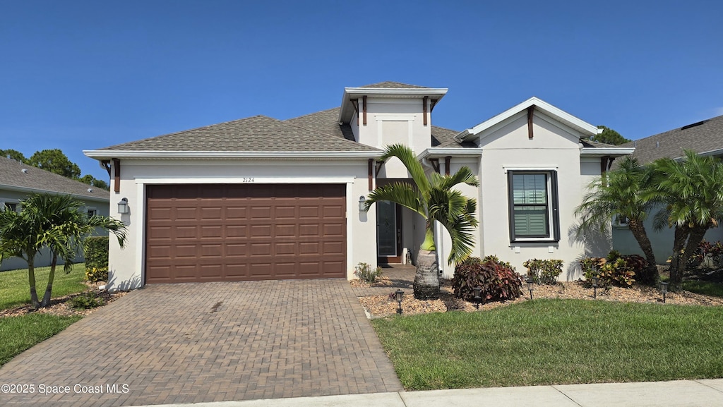 2124 Trift Bridge Cir, Melbourne, FL 32940 - view of front facade with a garage, decorative driveway, stucco siding, and a front lawn
