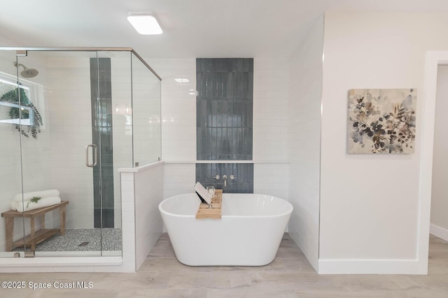 3201 Nottingham Ln, Cocoa, FL 32926 - bathroom featuring a freestanding tub, a shower stall, and tile walls