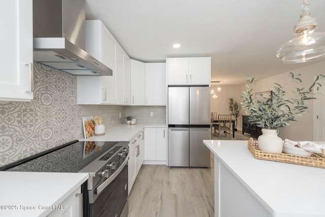 3201 Nottingham Ln, Cocoa, FL 32926 - kitchen featuring wall chimney exhaust hood, appliances with stainless steel finishes, white cabinetry, light wood-type flooring, and light countertops
