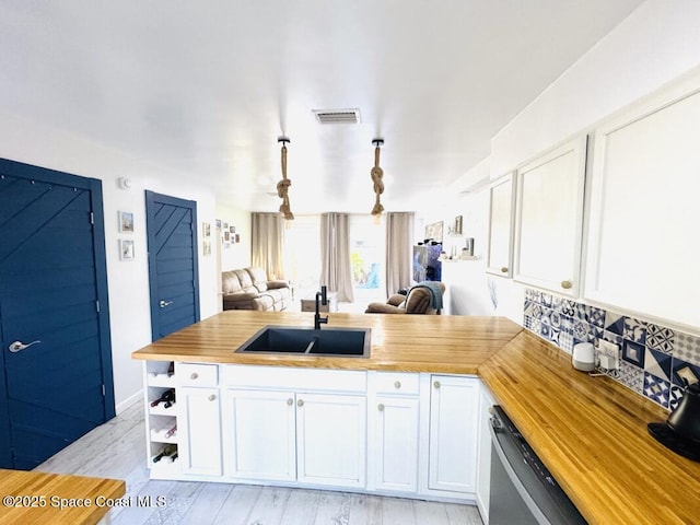 930 S Colonial Ct Unit 119, Indian Harbour Beach, FL 32937 - kitchen with butcher block countertops, a sink, open floor plan, dishwasher, and white cabinets