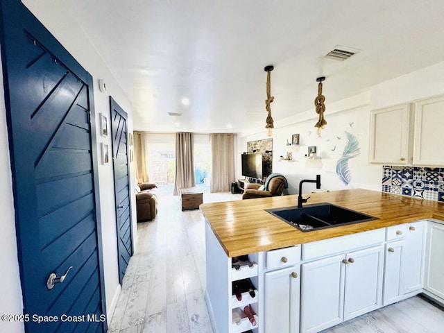 930 S Colonial Ct Unit 119, Indian Harbour Beach, FL 32937 - kitchen with a sink, open floor plan, wooden counters, a peninsula, and light wood-style flooring
