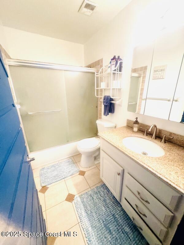 930 S Colonial Ct Unit 119, Indian Harbour Beach, FL 32937 - full bathroom with vanity, a shower with door, toilet, and tile patterned floors