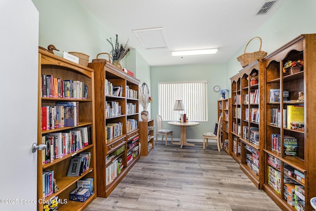 1410 Huntington Ln Unit 1204, Rockledge, FL 32955 - sitting room with wall of books, wood finished floors, and baseboards