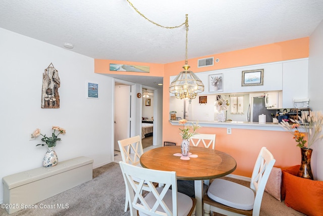 1410 Huntington Ln Unit 1204, Rockledge, FL 32955 - dining room with light colored carpet, a chandelier, a textured ceiling, and baseboards