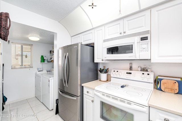 1410 Huntington Ln Unit 1204, Rockledge, FL 32955 - kitchen featuring white appliances, washing machine and clothes dryer, light countertops, light tile patterned flooring, and white cabinetry