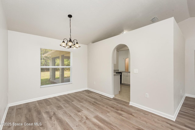1094 Locust Ave NW, Palm Bay, FL 32907 - empty room featuring lofted ceiling, arched walkways, light wood-style flooring, a chandelier, and baseboards