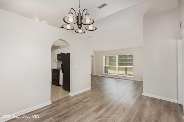 1094 Locust Ave NW, Palm Bay, FL 32907 - empty room featuring a chandelier, arched walkways, light wood-type flooring, baseboards, and high vaulted ceiling